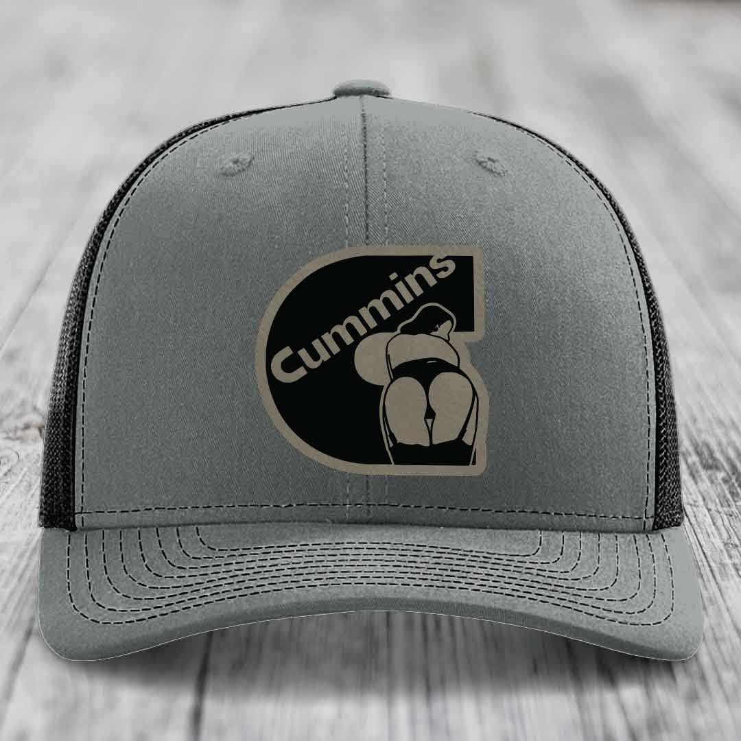Grey trucker hat with white mesh back and embroidered Cummins logo patch.