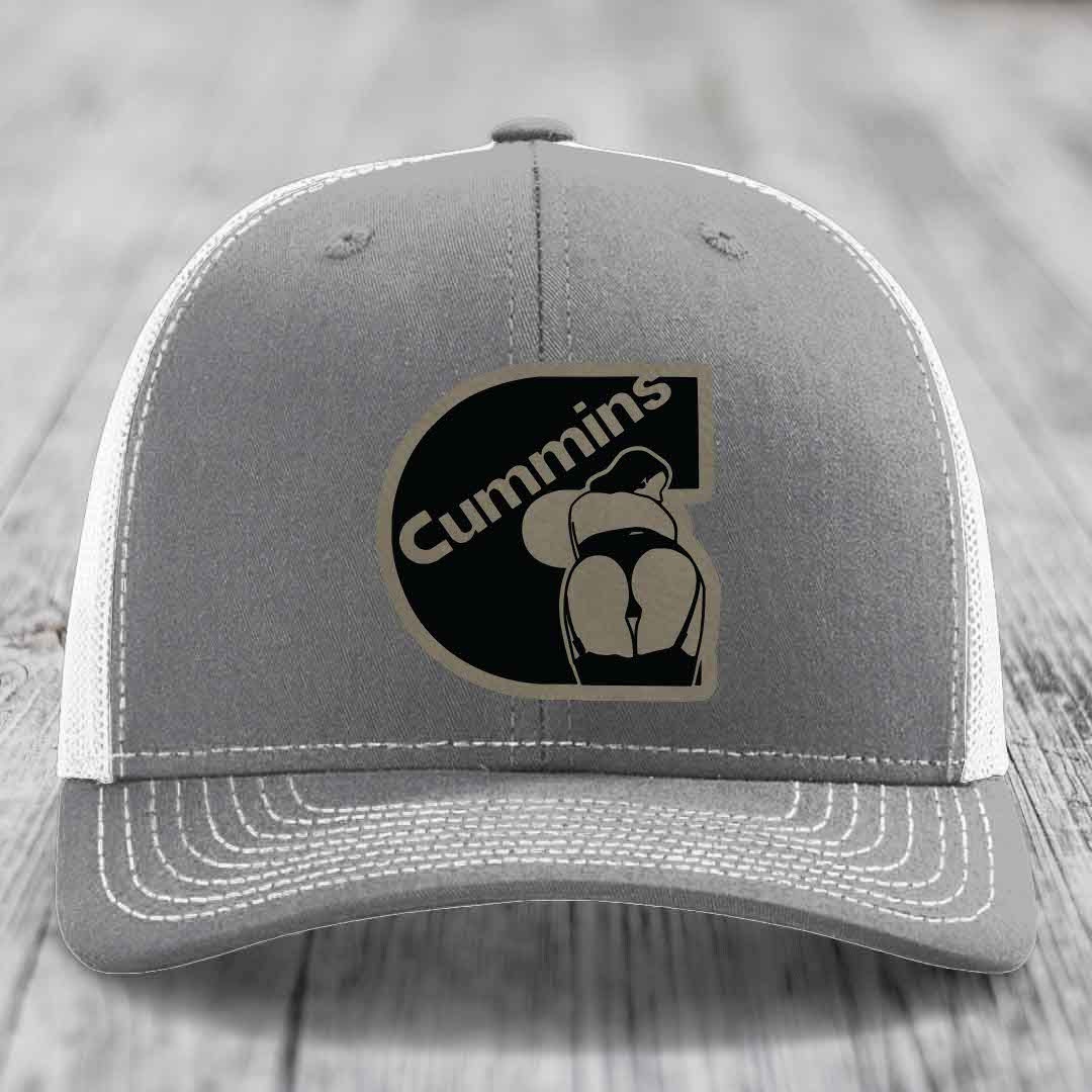 Pink trucker hat with black mesh back and gray stitched details, featuring a Cummins logo patch.
