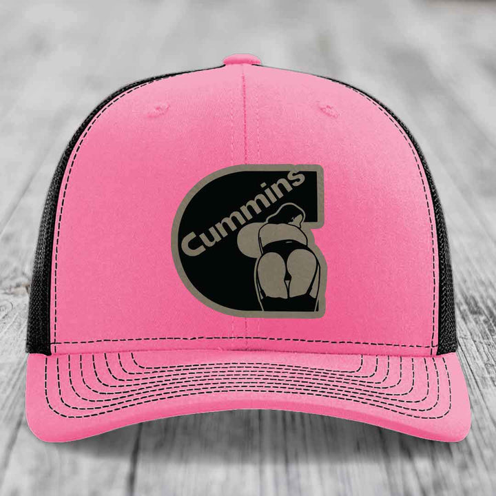 Green trucker hat with white mesh back and embroidered Cummins logo patch.