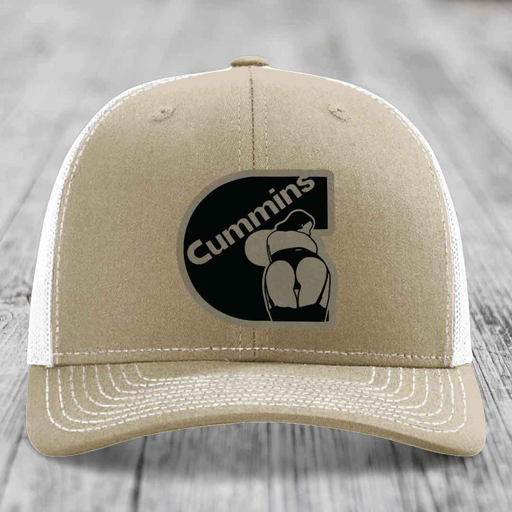 Olive green trucker hat with Cummins logo patch on front, featuring a stylized engine graphic.