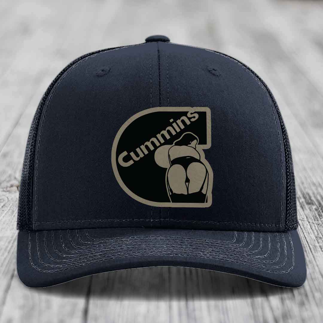 Purple trucker hat with black and tan Cummins logo patch on front.