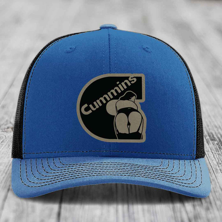Blue and red trucker hat with Cummins logo patch on front, white mesh back, and white stitching.