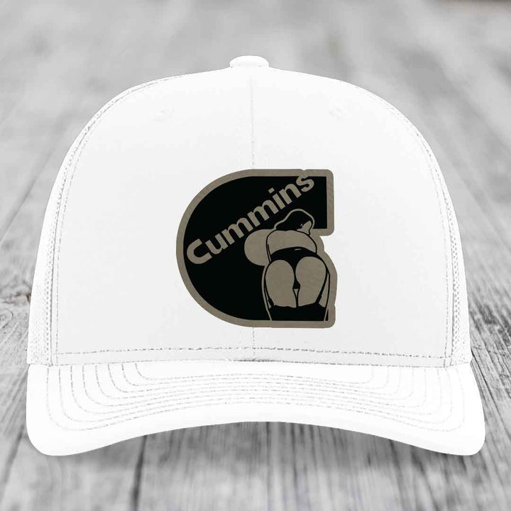 Black trucker hat with brown Cummins logo patch featuring a stylized figure.