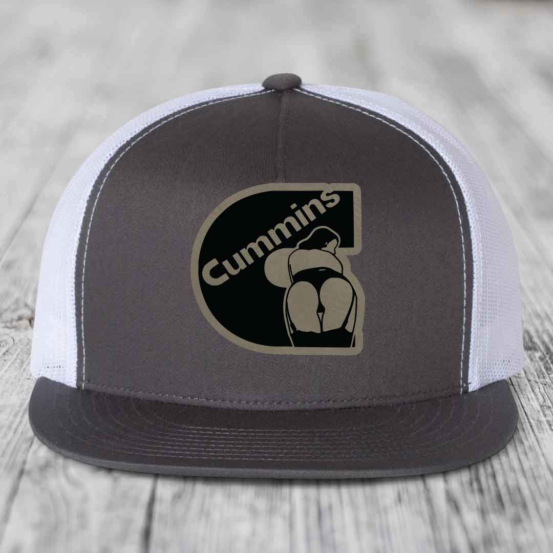 Black snapback trucker hat with brown Cummins logo patch featuring a stylized figure.