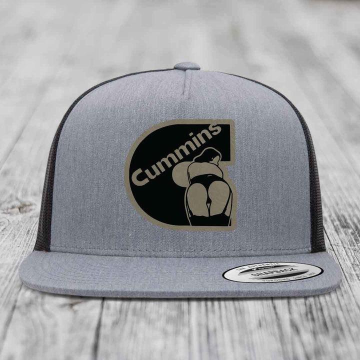 Grey trucker hat with black and tan Cummins logo patch on front, white mesh back.
