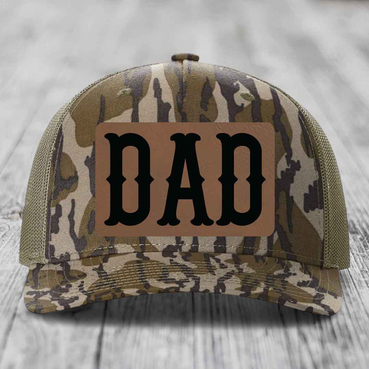 Blue and white trucker hat with a brown leather patch that says &