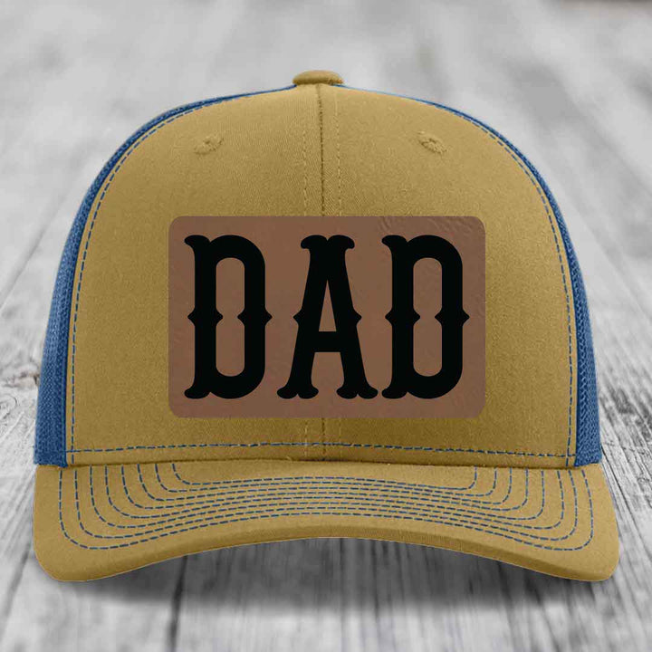 Black trucker hat with brown leather patch that says DAD in black letters.