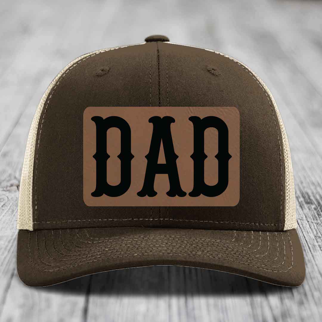 Green trucker hat with brown leather patch that says DAD in black letters.