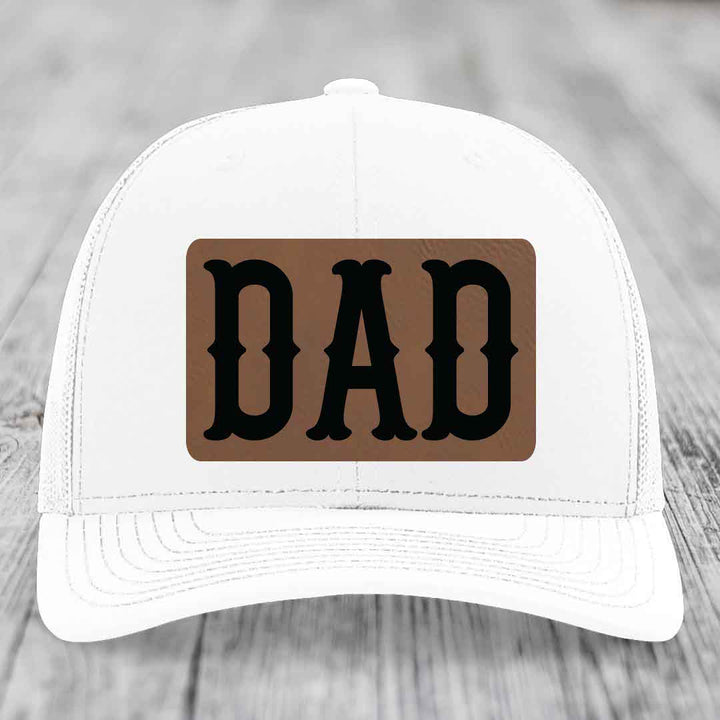 Camouflage trucker hat with brown leatherette patch that says DAD in black letters.