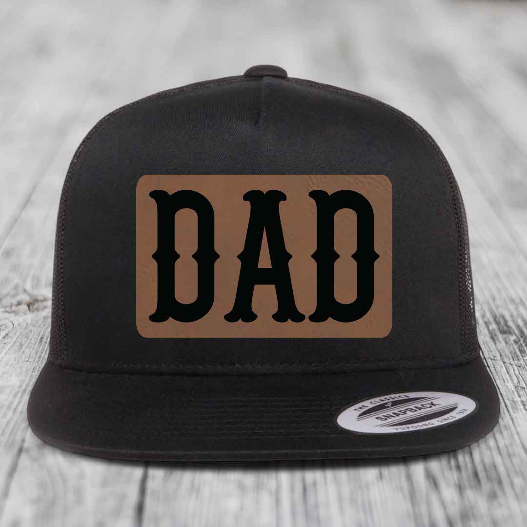 Black and white trucker hat with brown leather patch that says DAD in black letters.