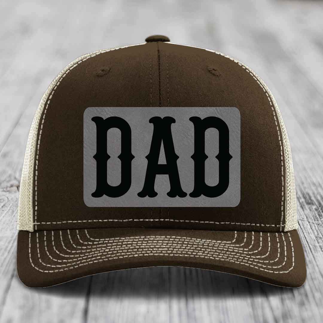 Tan trucker hat with black mesh back and gray rectangular patch that says &