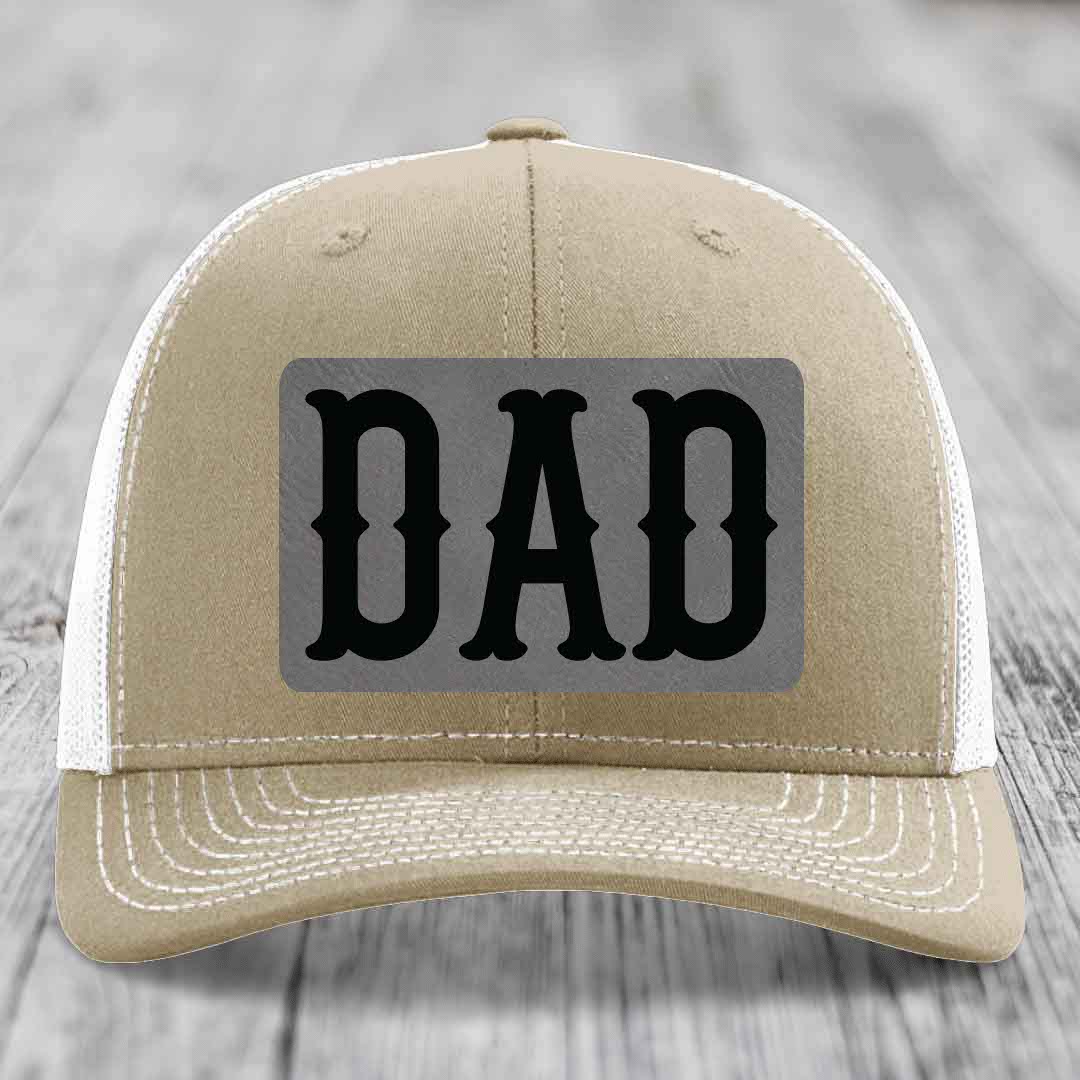 Olive green trucker hat with a grey rectangular patch that says &