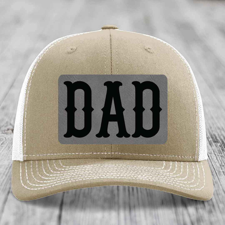 Olive green trucker hat with a grey rectangular patch that says &