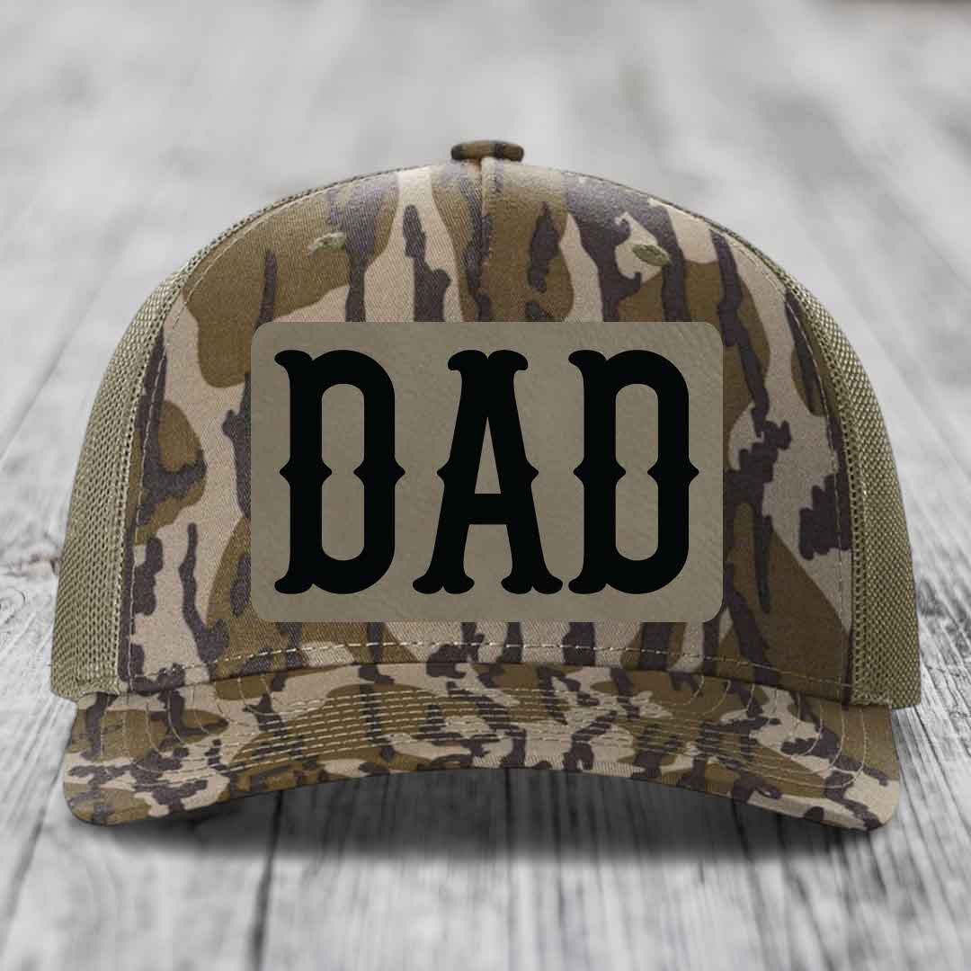 Blue and white trucker hat with a brown leatherette patch that says DAD in black letters.