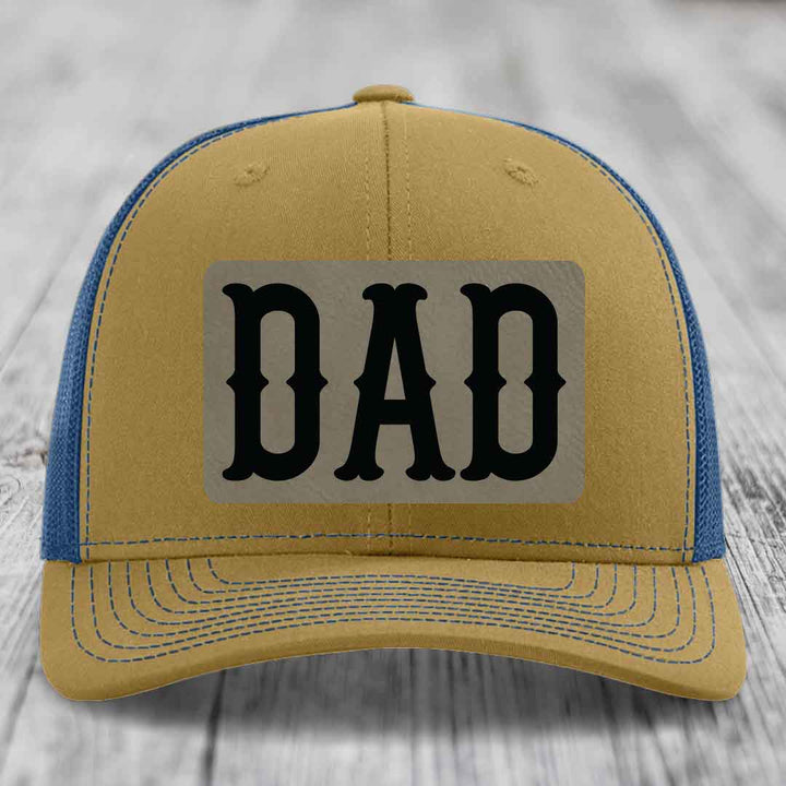 Black trucker hat with beige rectangular patch featuring black &