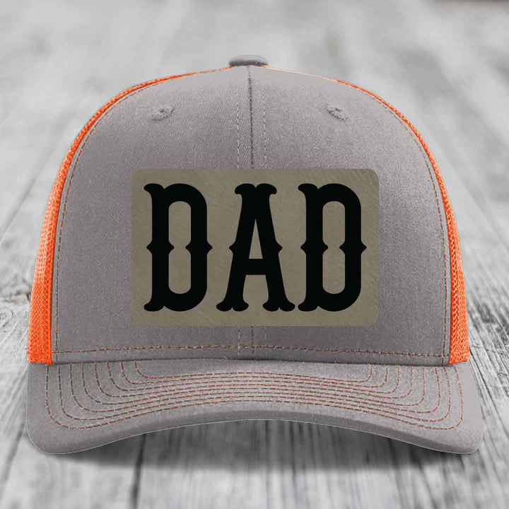 Grey trucker hat with pink mesh sides and a black &