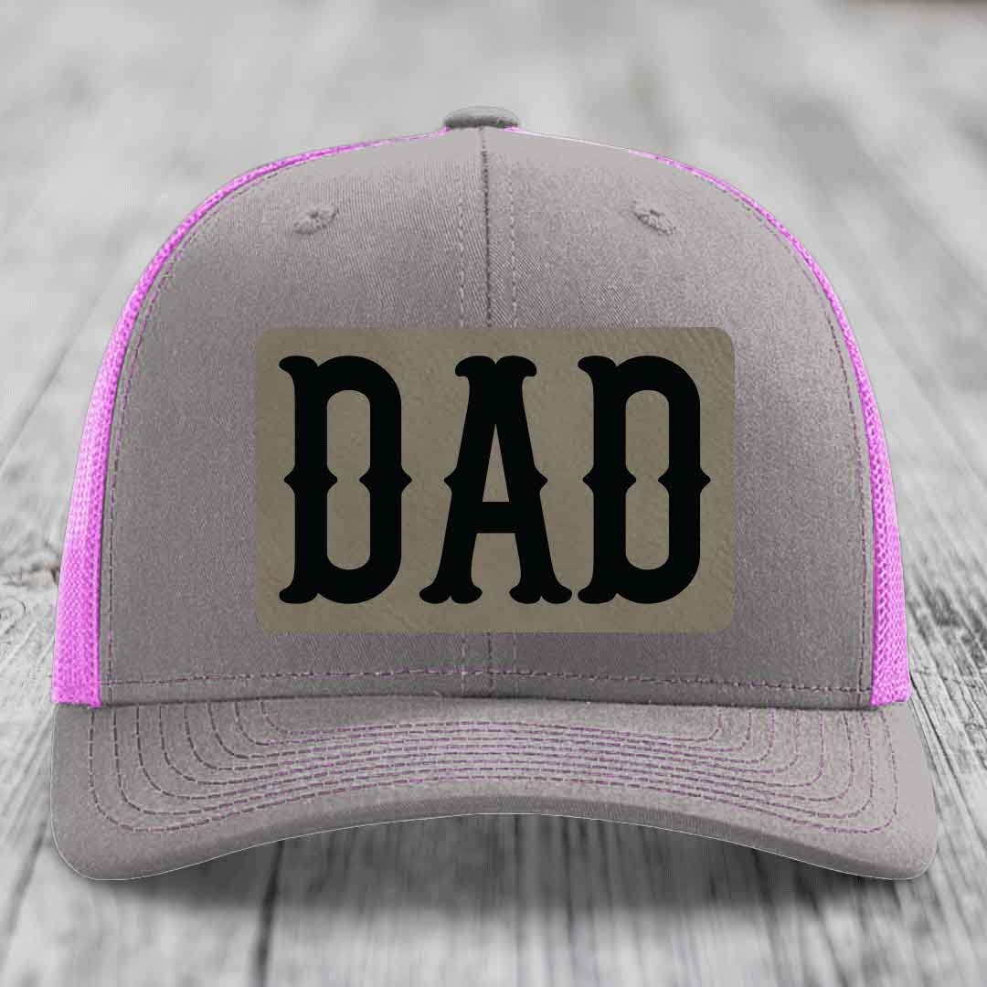 Grey trucker hat with yellow mesh sides and stitching, featuring a black &
