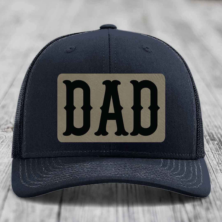 Purple trucker hat with a beige leatherette patch that says DAD in black letters.