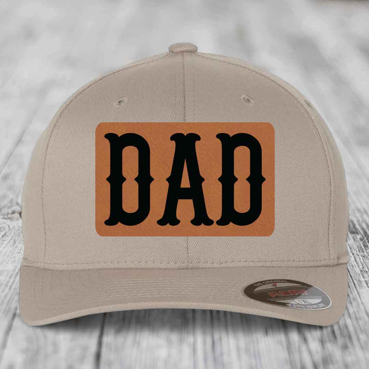 Dark blue baseball cap with a light brown leatherette patch that says &