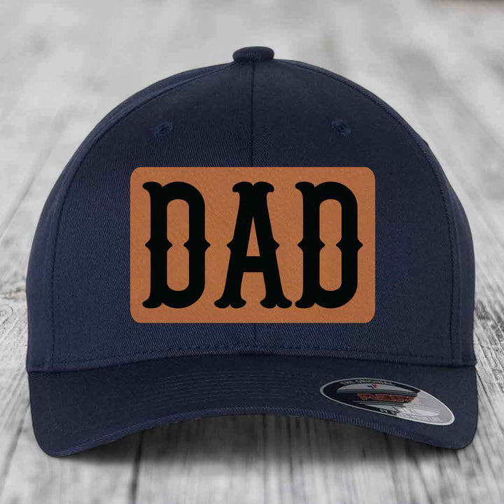 Dark blue baseball cap with a light brown leatherette patch that says &