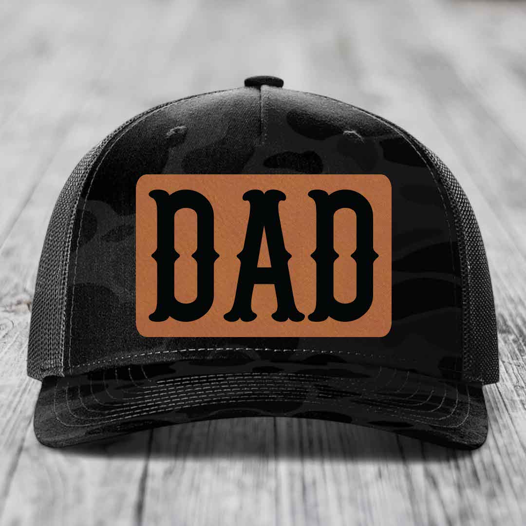 Camouflage trucker hat with brown leather patch reading &