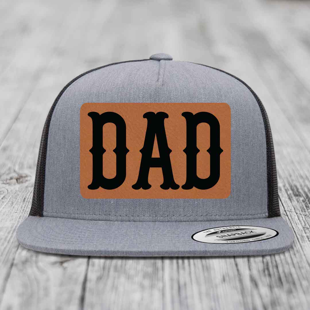 Grey trucker hat with brown leather patch that says DAD in black letters.