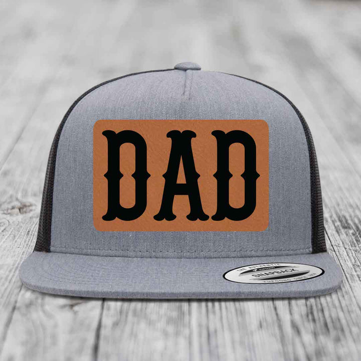 Grey trucker hat with brown leather patch that says DAD in black letters.