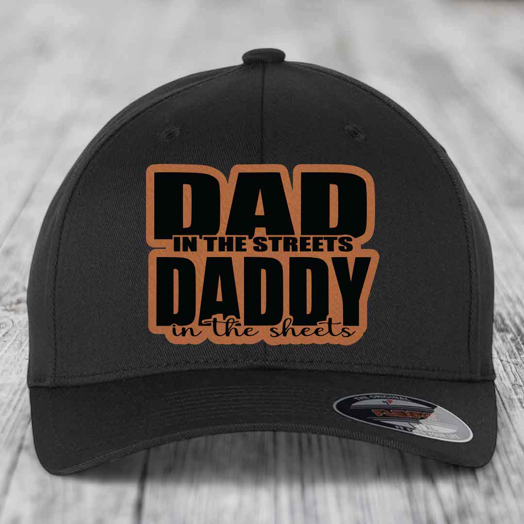 Black baseball cap with brown leatherette patch reading &