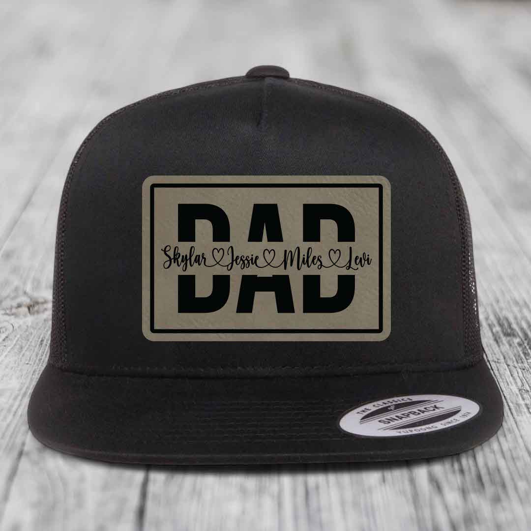 Black and white trucker hat with a beige leatherette patch featuring &