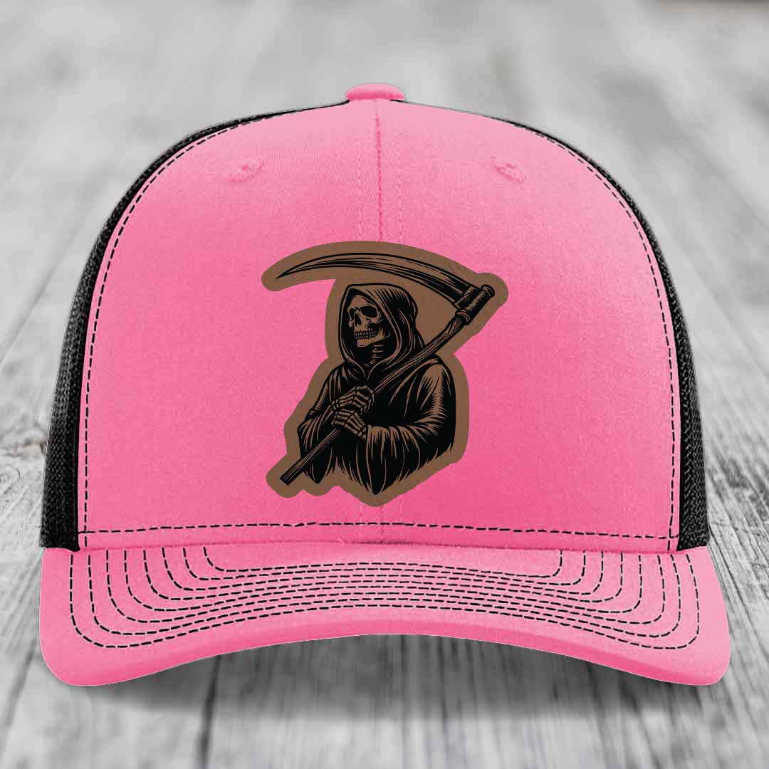 Pink trucker hat with black Grim Reaper patch on front, black mesh back and adjustable strap.