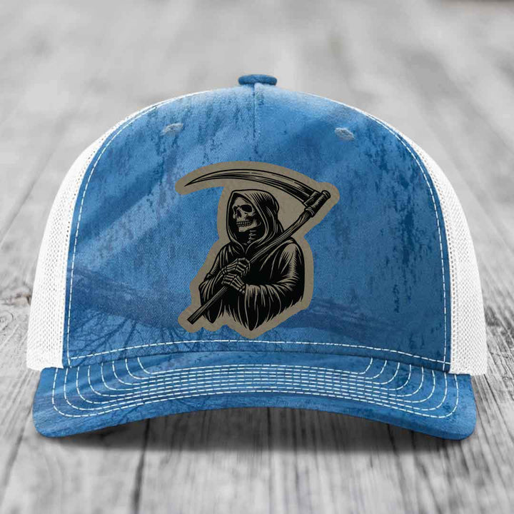 Blue and white trucker hat with Grim Reaper leather patch on front.