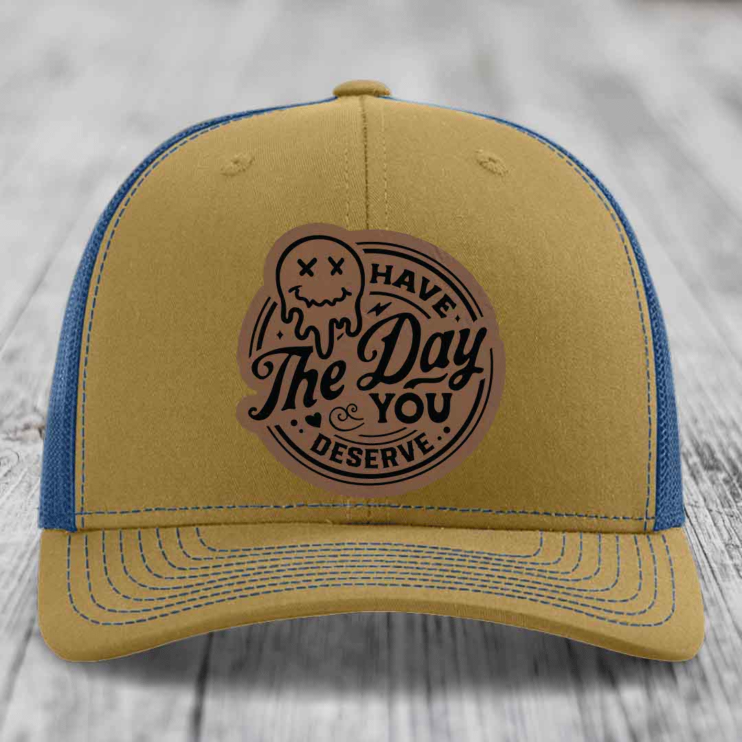 Tan trucker hat with blue mesh back and embroidered &
