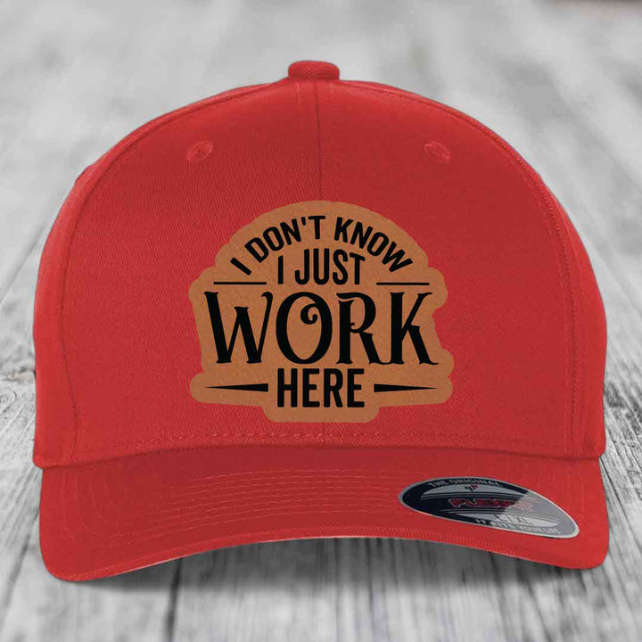 Red baseball cap with brown leatherette patch reading &
