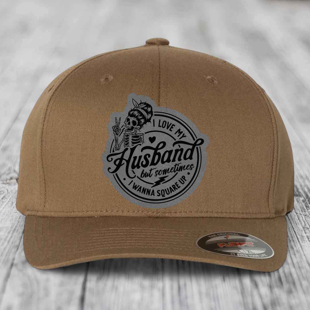 Tan baseball cap with grey circular patch featuring skeleton graphic and text &