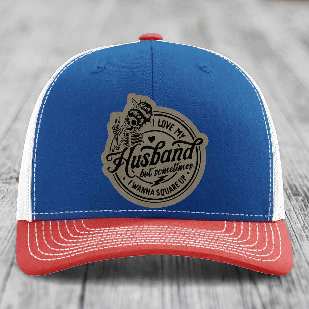 Blue and red trucker hat with skull patch reading &