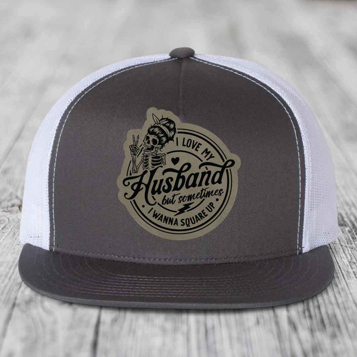 Grey and white trucker hat with skull patch reading &