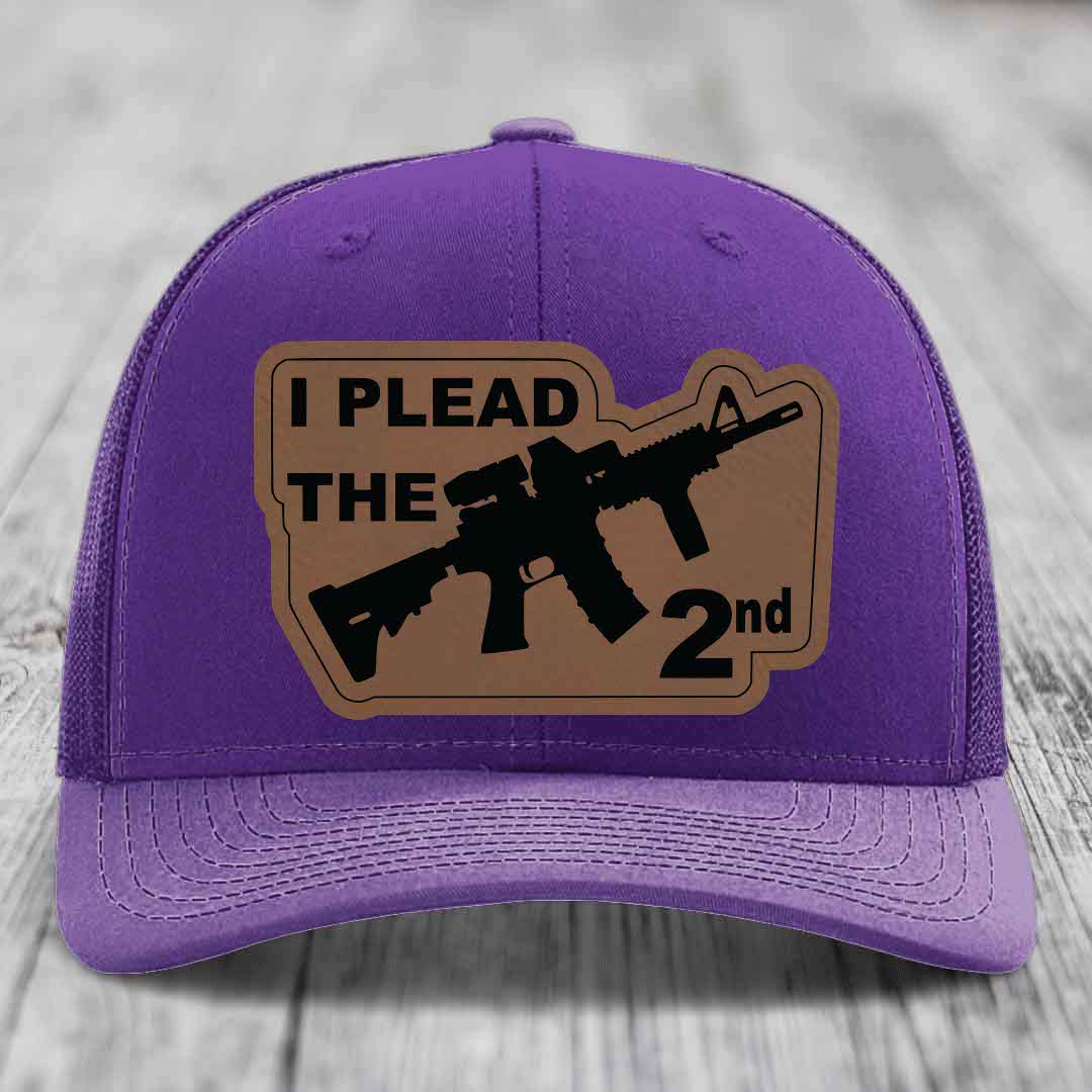 Purple trucker hat with brown leather patch reading &