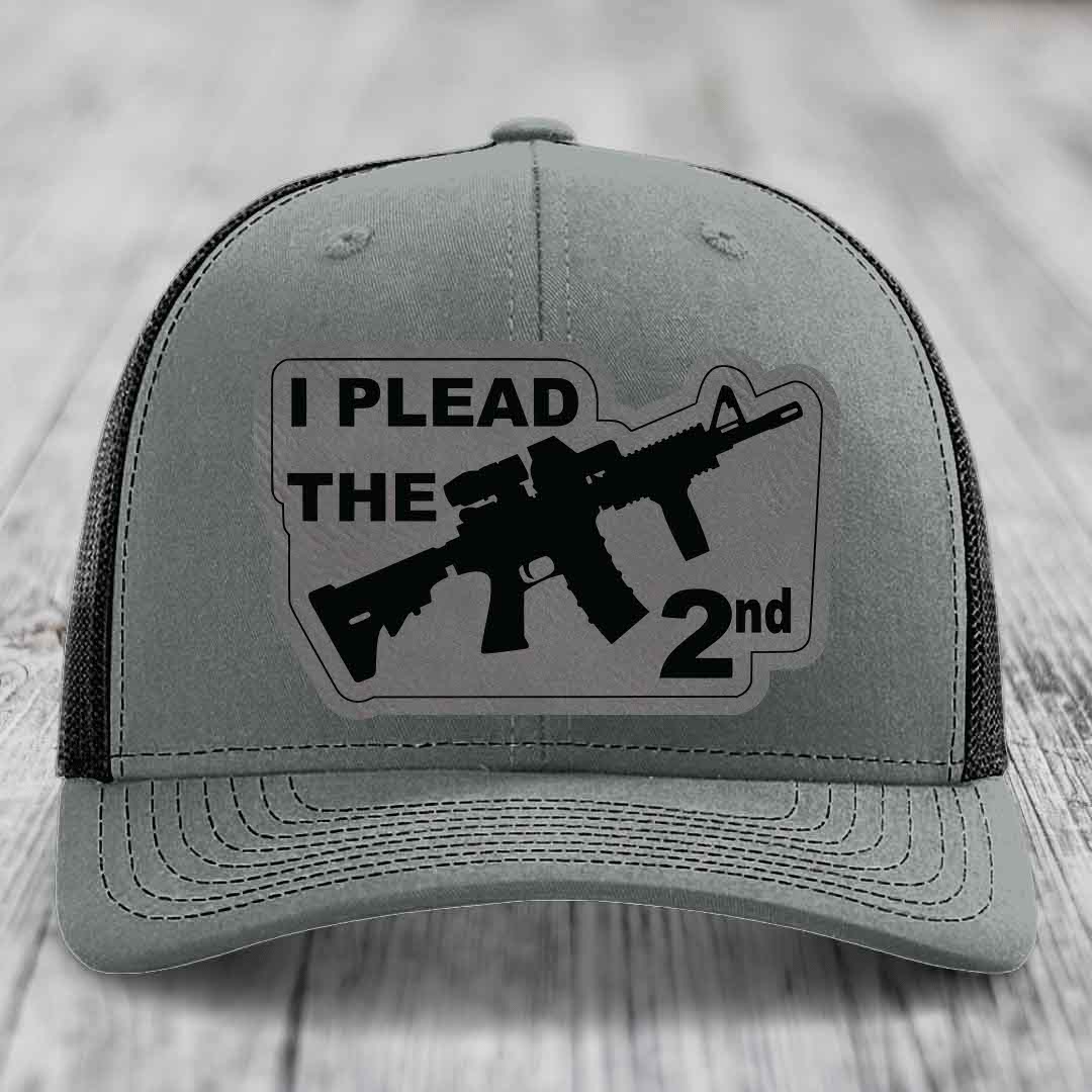 Grey trucker hat with black patch reading &