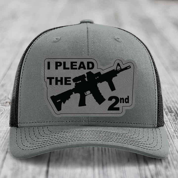 Grey trucker hat with black patch reading &