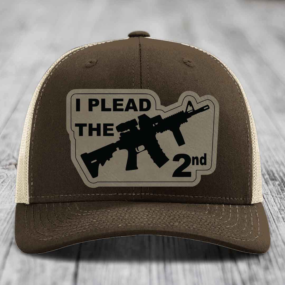 Brown trucker hat with beige mesh back and black patch reading &