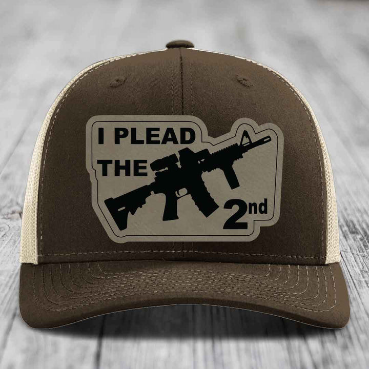 Brown trucker hat with beige mesh back and black patch reading &