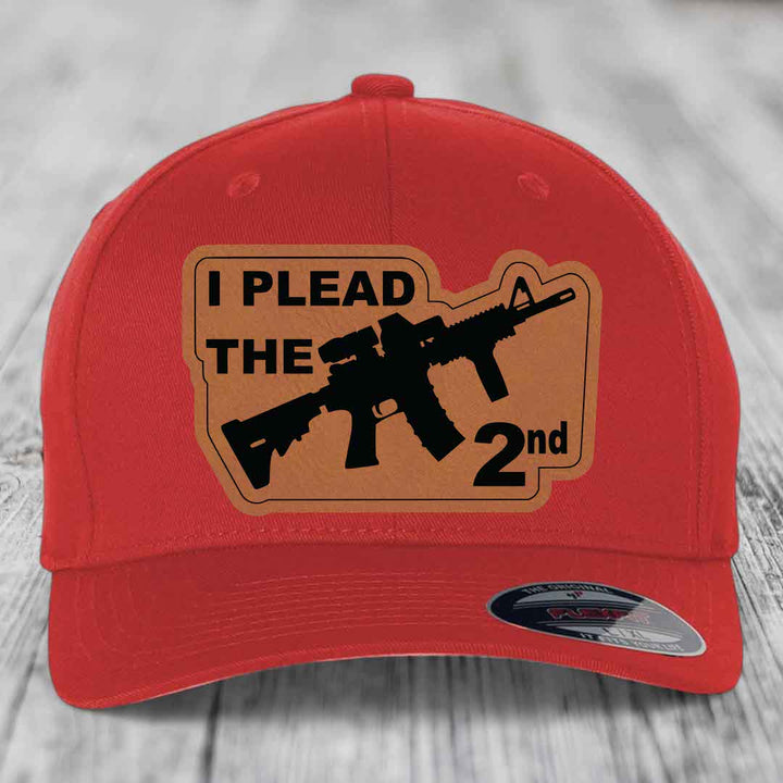 Red baseball cap with tan leather patch reading &