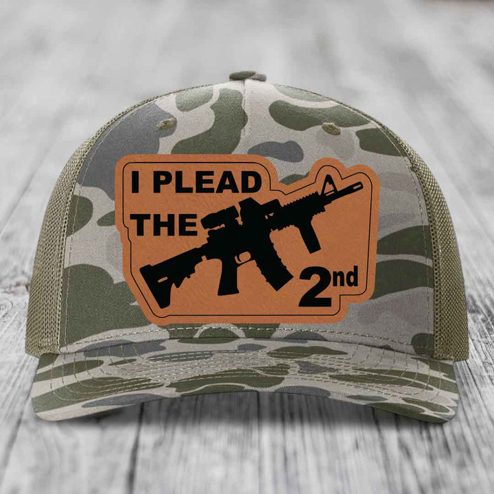 Camouflage trucker hat with brown leather patch reading &