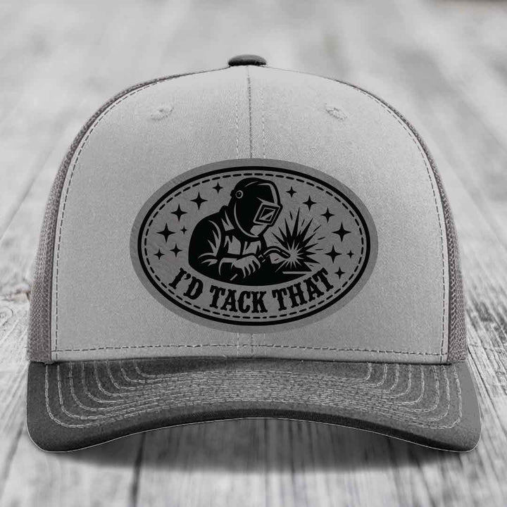 Grey trucker hat with black oval patch showing welder and text &