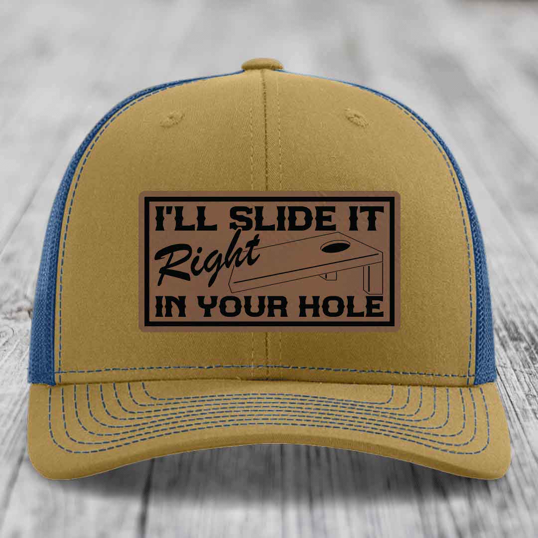 Tan and blue trucker hat with a brown leatherette patch that says &