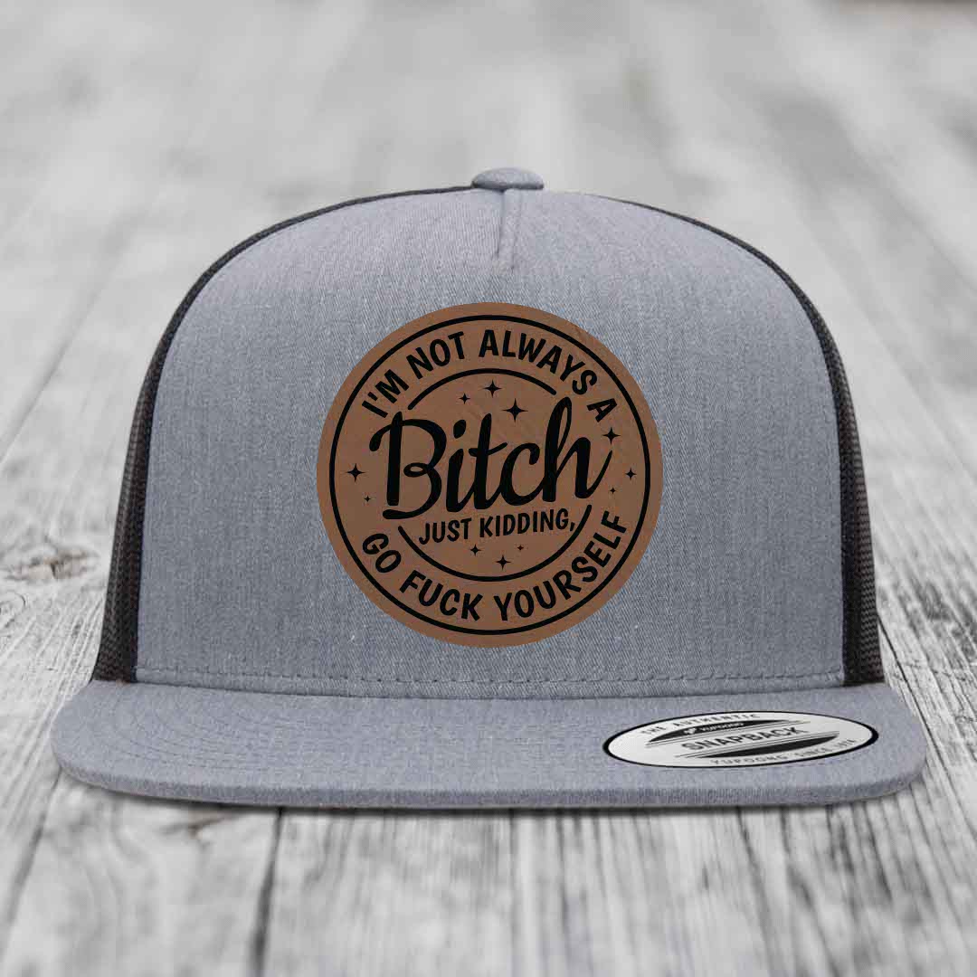 Grey trucker hat with brown circular leather patch reading &