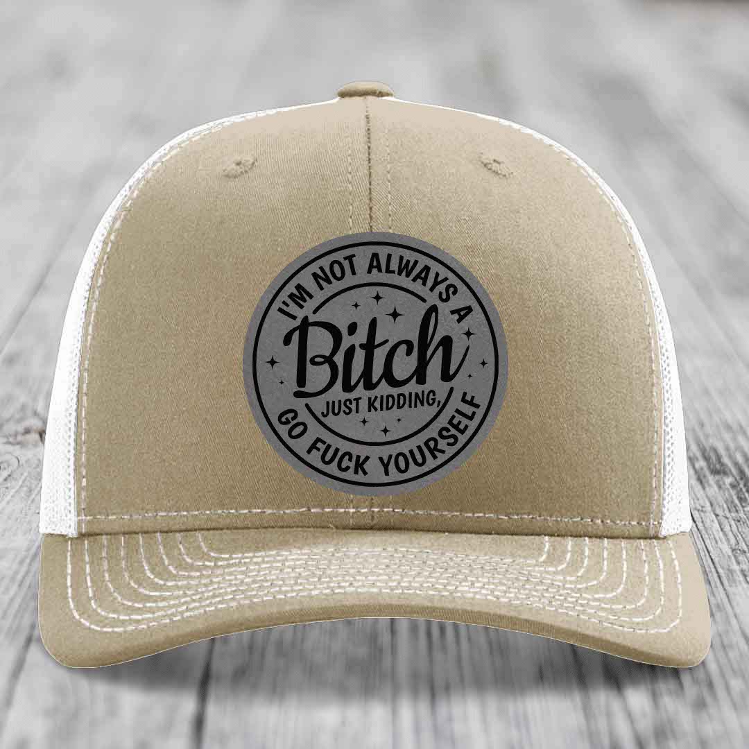 Tan trucker hat with white mesh back and gray circular patch reading &
