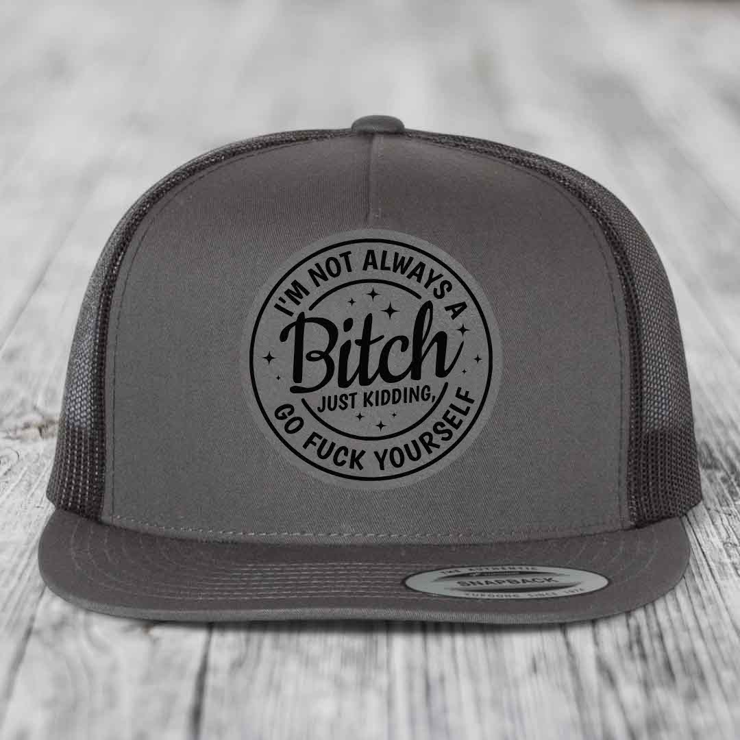 Grey trucker hat with black circular patch reading &