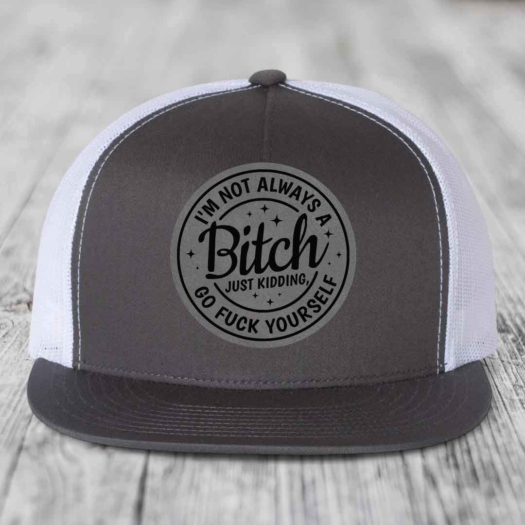 Grey and white trucker hat with circular black text patch reading &
