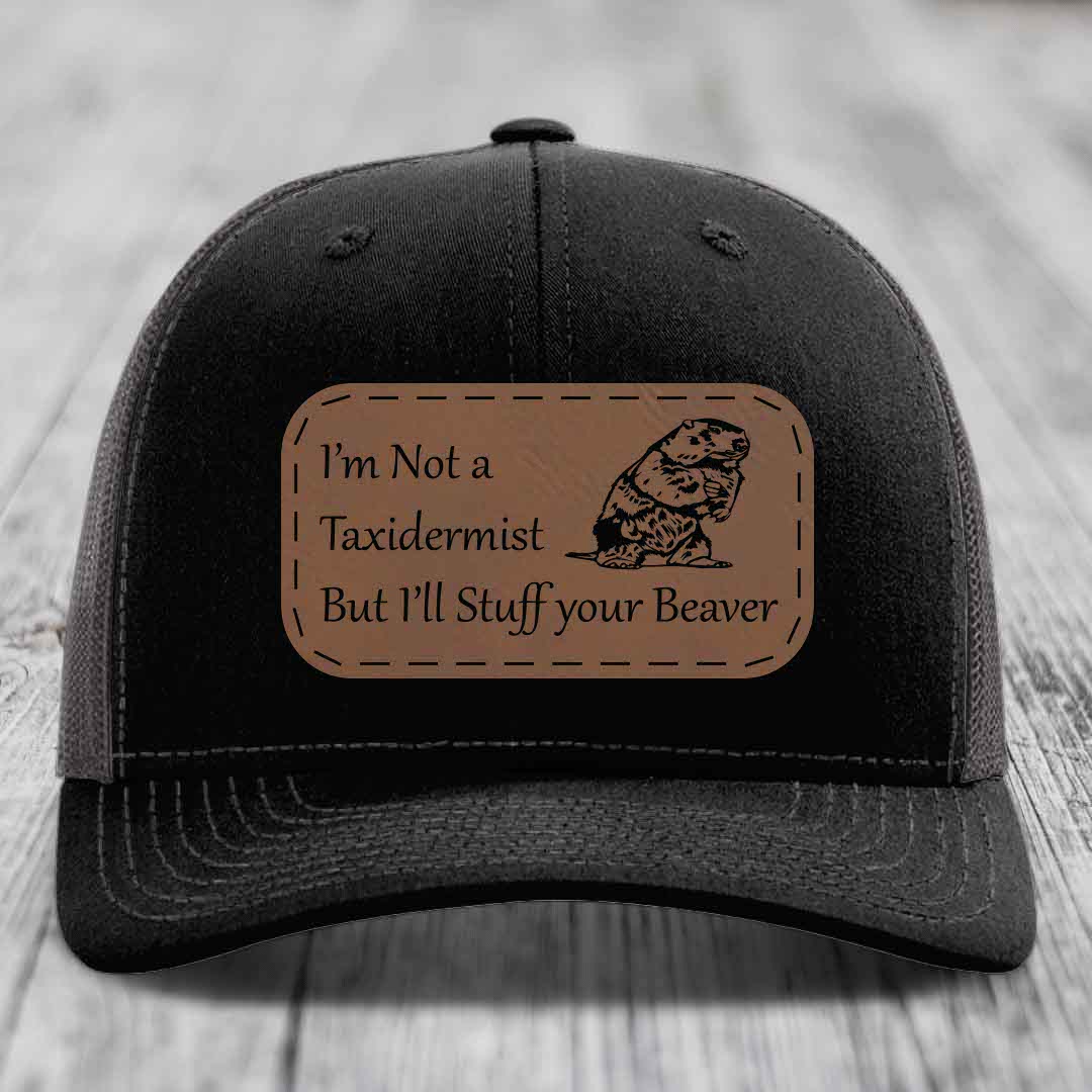 Black trucker hat with brown leather patch reading &